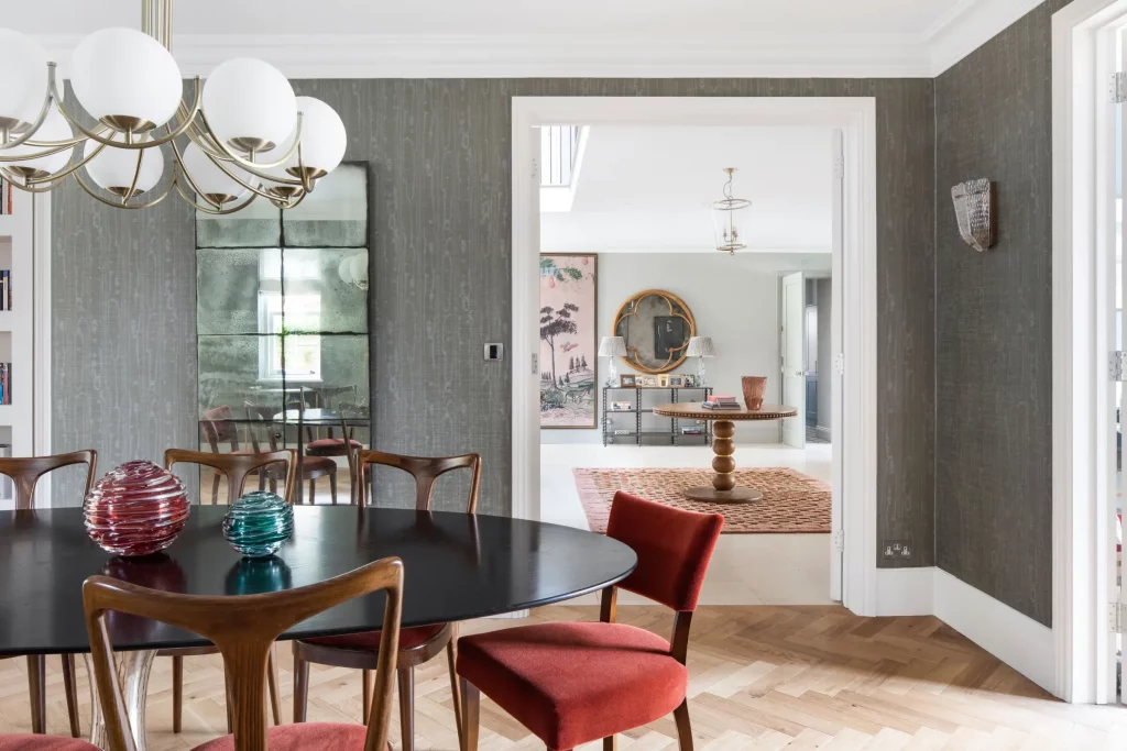 A dining room refurbishment that shows how high standard Blenford renovations in Oxford can be. It shows a green room with light wooden flooring and a dining table.